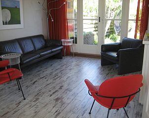 Living room of The Duinputter vacation home De Koog Texel with modern furnishings and garden view.
