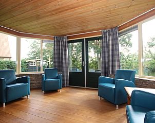 Veranda of Landhuis Landleven No. 81, vacation home in De Koog, Texel overlooking green surroundings.