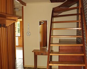 Stairs in Landhuis Landleven No. 81, vacation home in De Koog, Texel with wooden details and access to upper floor.