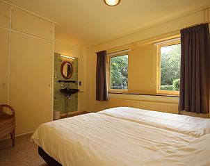 Bedroom in Landhuis Landleven No. 81, vacation home in De Koog, Texel with double bed and view of nature.