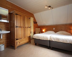 Wooden bedroom of Landhuis Landleven No. 81, vacation home in De Koog, Texel with comfortable beds.