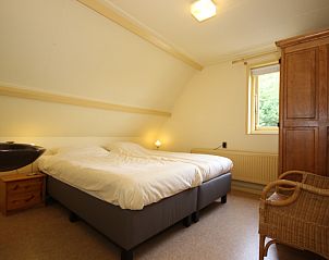Cozy bedroom in Landhuis Landleven No. 81, vacation home in De Koog, Texel with double bed and wooden furniture.