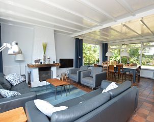 Gemtliches Wohnzimmer in Orchismient 45 groes Ferienhaus De Koog Texel mit bequemen Sitzgelegenheiten und Kamin.