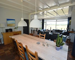 Helles Esszimmer in Orchismient 45 groes Ferienhaus De Koog Texel mit groem Tisch und stimmungsvoller Beleuchtung.