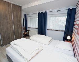 Gemtliches Schlafzimmer in Orchismient 45 groes Ferienhaus De Koog Texel mit groen Fenstern und viel Stauraum.