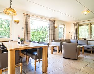 Dining room in Villa, De Koog, Texel with large table and view of green surroundings.