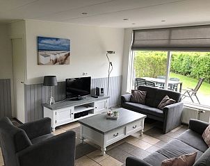 Bright living room in Bungalow 33, De Koog, Texel, overlooking the garden and modern furnishings for a pleasant vacation on the Wadden Islands.