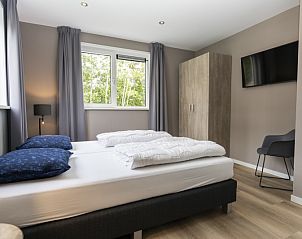 Bedroom in Villa 17, De Koog, Texel with comfortable double bed and view of green nature for ultimate relaxation.