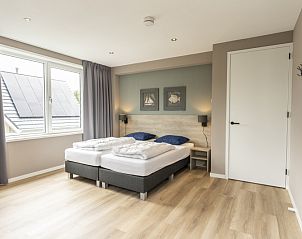 Spacious bedroom with large window in Villa 17, De Koog, Texel offers plenty of natural light and a serene atmosphere.