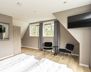 Villa 17 in De Koog, Texel features a modern bathroom with bathtub and sleek design for a luxurious vacation experience.