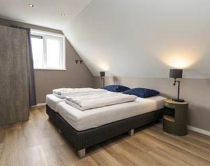 Villa 17 in De Koog, Texel offers a bedroom with modern design and large windows for a light and spacious feeling.