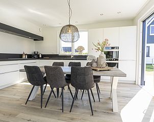Dining room in Villa 35a, De Koog, Texel with modern kitchen and large table.