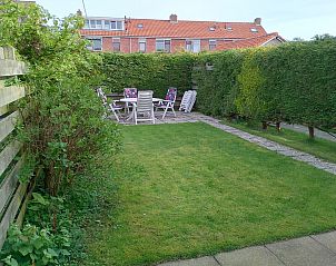 Sunny garden at vacation home Watersnip, De Koog, Texel with seating and greenery.
