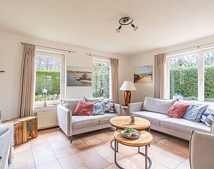Stilvolle Sitzecke im Ferienhaus Honeysuckle 81, De Koog, Texel mit bequemen Sofas und Blick auf den grnen Wattenmeer-Garten.