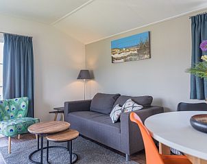 Cozy living room in Chalet Bregkoog 227, Chaletpark Bregkoog, De Koog, Texel with comfortable sofa and colorful armchair.