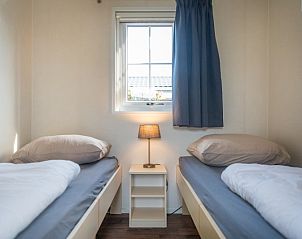 Second bedroom in Chalet Bregkoog 227, Chaletpark Bregkoog, De Koog, Texel with two single beds and atmospheric lighting.