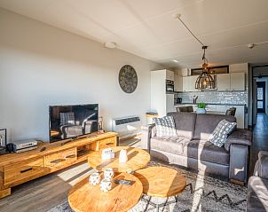 Moderne woonkamer met televisie in Appartement Juliana 048, gelegen in De Koog, Texel, met uitzicht op de omgeving.