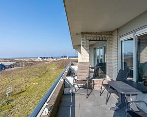 Ruim balkon met zitgelegenheid en zeezicht in Appartement Juliana 048, perfect voor ontspanning in De Koog, Texel.
