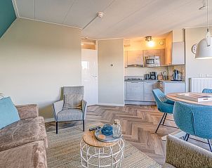 Dining room with round table in Apartment Zeedistel 22, De Koog, Texel with lots of natural light.