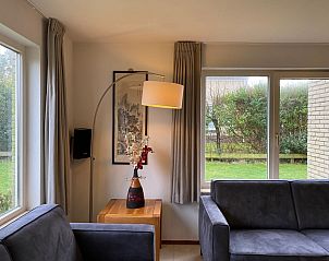 Cozy sitting area in Holiday home Kamperfoelie 53 at Villapark Kamperfoelie, De Koog, Texel with garden view.