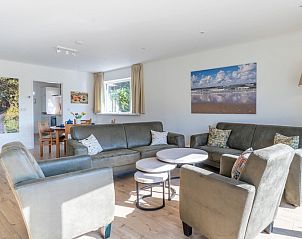 Cozy interior of Orchismient 14 vacation home in De Koog Texel with modern decor and art on the wall.