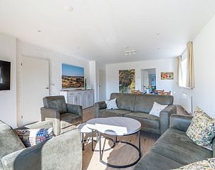Bright living room of Orchismient 14 vacation home De Koog Texel with comfortable sofas and access to dining area.