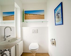 Fresh bathroom in Orchismient 14 vacation home De Koog Texel with modern sink and wall decoration.