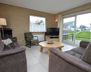 Cozy living room in Holiday home Stappeland 213, De Koog, Texel with comfortable seating area and garden view.