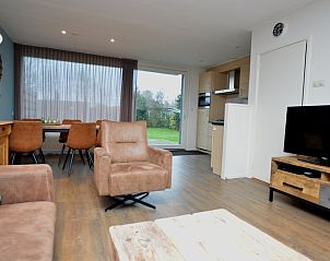 Lichte woonruimte in Epelaan 19 vakantiehuis, De Koog, Texel, met eetgedeelte en tuinzicht.