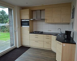 Moderne keuken in Epelaan 19 vakantiehuis, De Koog, Texel, met uitzicht op de tuin.