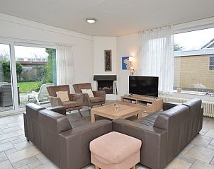 Cozy living room of vacation home Epelaan 31 in De Koog, Texel with modern furnishings and garden views.