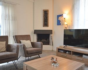 Comfortable sitting area with fireplace in Epelaan 31, vacation home in De Koog, Texel, ideal for relaxation.