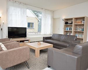 Bright living room with bookcase in vacation home Epelaan 31, De Koog, Texel, perfect for reading lovers.