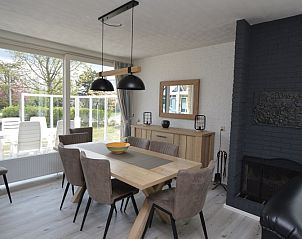 Dining room in Orchismient 33 vacation home De Koog Texel overlooking green surroundings.