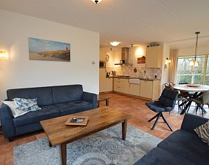 Vacation home 7K in De Koog, Texel offers a stylish living and dining area with access to the garden, ideal for a cozy stay.