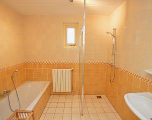 Modern bathroom in Holiday home 7K, De Koog, Texel with bathtub and shower, perfect for relaxing after a day on the island.