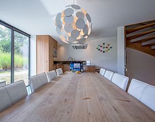 Spacious dining room in Park Duynzoom - Villa Duynzoom, Texel, with large table and stylish lamp.