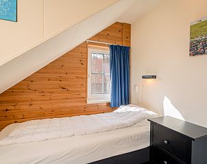 Cozy single bedroom in Maaikeduinweg 13 vacation home, De Koog, Texel with wooden interior and comfortable bed.