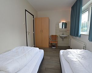 Cozy bedroom in vacation home Orchismient 27, De Koog, Texel, with single beds and sink.