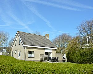 Vacation home Stappeland 207 in De Koog, Texel offers a charming exterior surrounded by greenery, ideal for a relaxing stay.