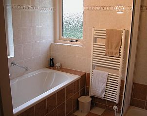 Modern bathroom in Bungalow 25, De Koog, Texel, with bathtub and natural light.