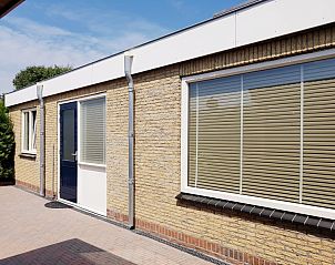 Auenansicht des Ferienhauses 1, De Koog, Texel mit Backsteinfassade und groen Fenstern.