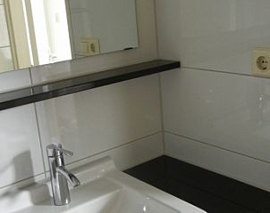 Waschbecken im Badezimmer des Ferienhauses 1, De Koog, Texel mit Spiegel und Ablage.