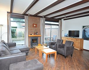 Cozy living room of Orchismient 28 De Koog Texel with fireplace and sitting area.
