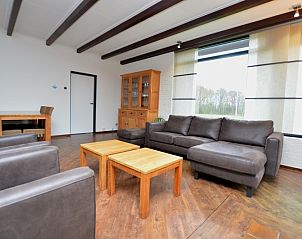 Spacious living room of vacation home Orchismient 28 De Koog Texel with wooden floor.