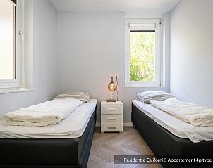 Second bedroom in Type 1 vacation home, De Koog, Texel with two single beds and garden view.