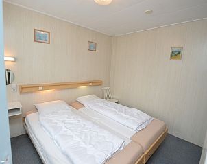Bedroom with double bed in vacation home Plevierstraat 18, De Koog, Texel with quiet decoration.