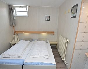 Second bedroom in Plevierstraat 18 vacation home, De Koog, Texel with two single beds and sink.