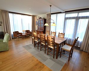 Spacious dining room in Orchismient 35 vacation home, De Koog Texel, with wooden floor and lots of light.