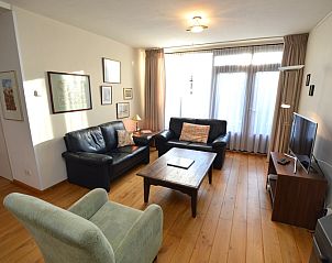 Comfortable sitting area in Orchismient 35 vacation home, De Koog Texel, with leather sofas.